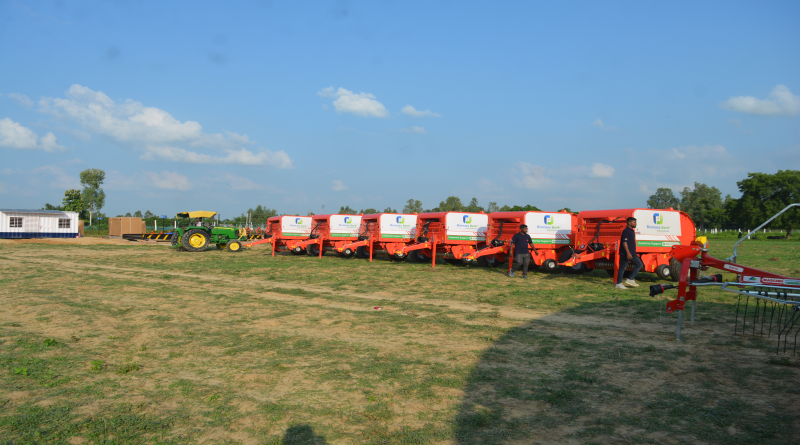 a row of farm equipment parked in a field