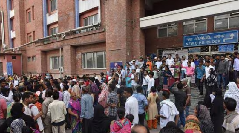 A large crowd gathers outside the entrance of a hospital building labeled "New O.P.D. Block" in India.