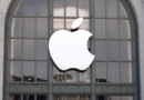 Apple logo in front of a building with arched windows.